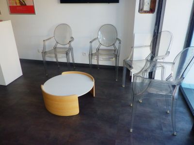 des chaises et une table dans une pièce où une télévision est accrochée au mur