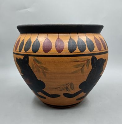 une image représentant un vase orné d'un chat noir