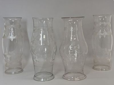 four glass vases sitting next to each other on a table