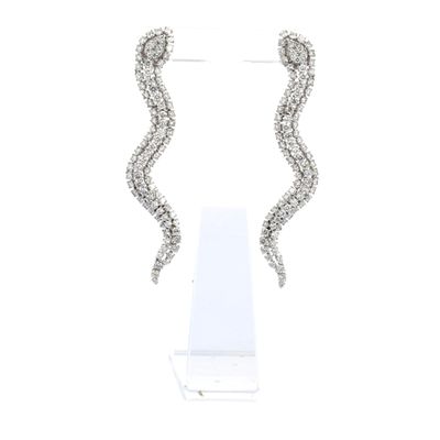 une paire de boucles d'oreilles en diamant posées sur un présentoir, sur fond blanc