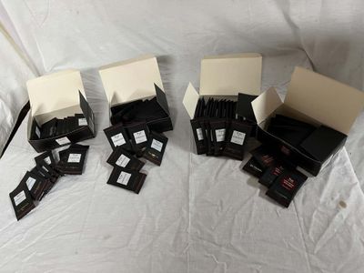 quatre cartons contenant des objets noirs et blancs posés sur un drap blanc