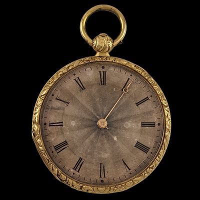 a gold pocket watch with roman numerals on the face