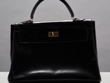un sac à main en cuir noir posé sur une table blanche