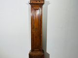 a tall wooden grandfather clock in the corner of a room