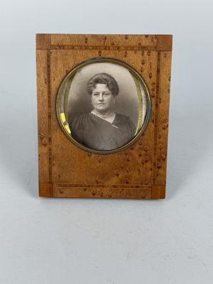 an old photo of a woman in a black dress in a wooden frame