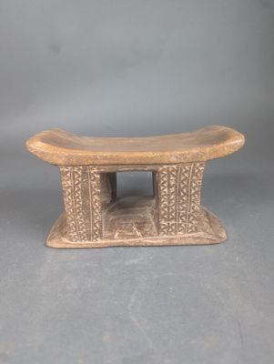 une image représentant un petit banc en bois posé sur une surface grise