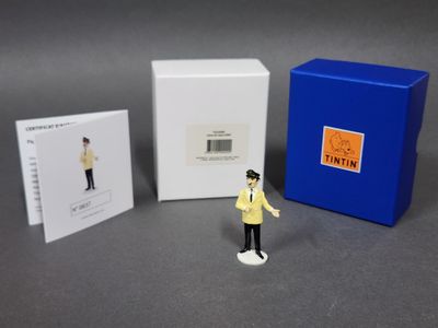 une petite figurine représentant un homme debout à côté d'une cabine téléphonique bleue