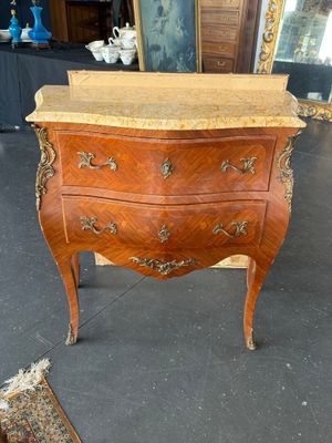 une petite commode en bois avec un plateau en marbre