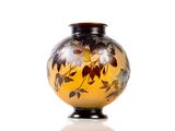 a yellow vase with black and white flowers on it