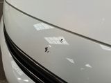 a close up of a white car with a black stripe on it