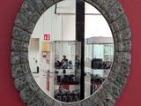a round mirror hanging on a red wall in a room