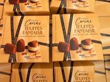 Plusieurs boîtes de truffes au chocolat sont empilées les unes sur les autres