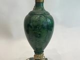 une image représentant un vase vert entouré d'une corde