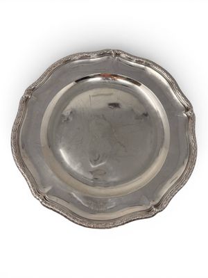 an antique silver plate on a white background with a red handle