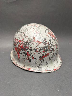 a white helmet with red paint on it sitting on a table