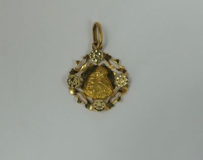 a close up of a gold pendant on a white surface