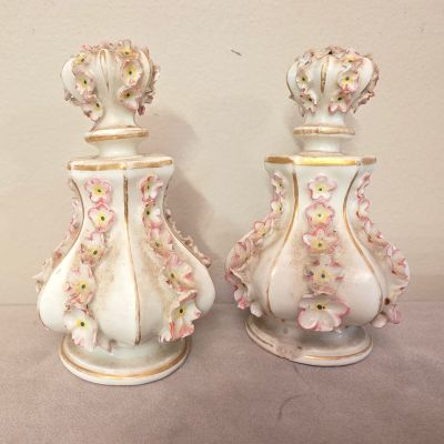 deux vases blancs ornés de fleurs roses, posés sur une table
