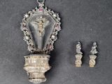 a silver object with a crucifix on it next to other items