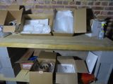 plusieurs cartons remplis d'objets posés sur une table, avec un mur de briques en arrière-plan