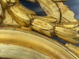 a gold clock with a gold leaf decoration on it