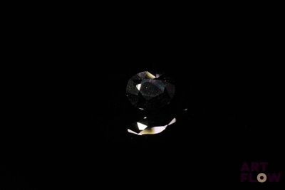 an image of a black diamond in the dark with a black background
