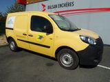 une petite camionnette jaune garée devant un immeuble
