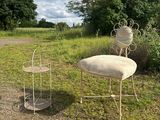 two chairs and a table in the middle of a field