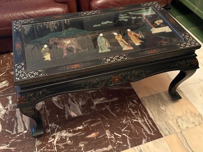 une table en verre sur laquelle est posé un tableau, dans un salon