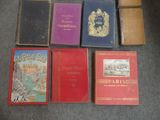 several books are lined up on a carpeted floor next to each other