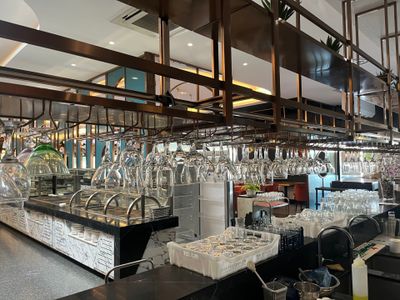 many wine glasses hanging from the ceiling in this restaurant
