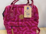 pink leopard print backpack with leather handles on wooden table