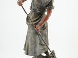 figurine représentant une femme en train de balayer le sol avec un balai