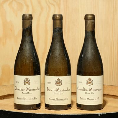 three bottles of wine sitting on a barrel of wine