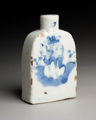 a small blue and white vase with a bird on it