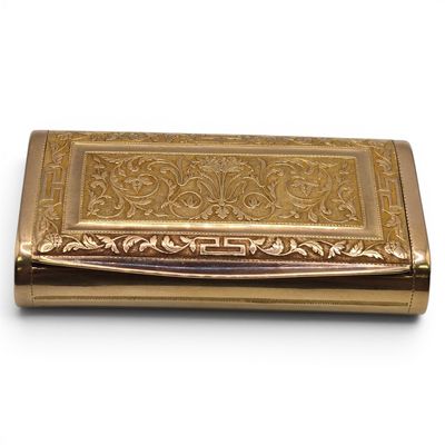 an image of a gold cigarette case sitting on a white surface