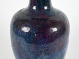 a blue vase that is sitting on a white surface