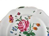 a white plate with a pink rose and blue flowers on it