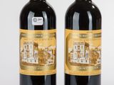 deux bouteilles de vin rouge posées l'une à côté de l'autre sur une surface blanche