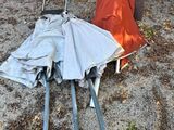 two umbrellas laying on the ground next to a table and chairs