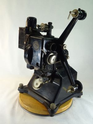 une machine noire posée sur un socle en bois