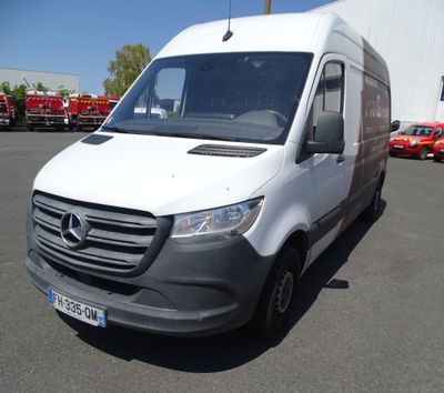 une camionnette blanche garée sur un parking à côté d'un bâtiment