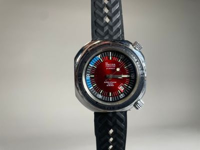 un gros plan d'une montre-bracelet au cadran rouge