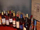 bottles of wine are lined up on a red table cloth