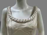 a mannequin wearing a white dress with a beaded neckline
