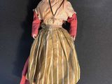 an old fashioned doll is sitting on a black surface