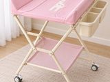 the baby changing table is pink and has a white giraffe on it