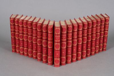 six red books stacked on top of each other on a gray surface
