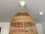 une lampe en osier suspendue au plafond dans une cuisine