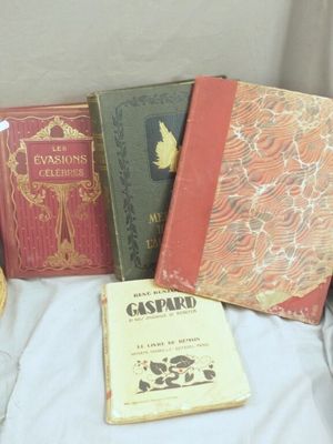 three books sitting on a bed next to a basket