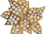 une broche en forme de fleur en or et diamants, signée Van Cleef
